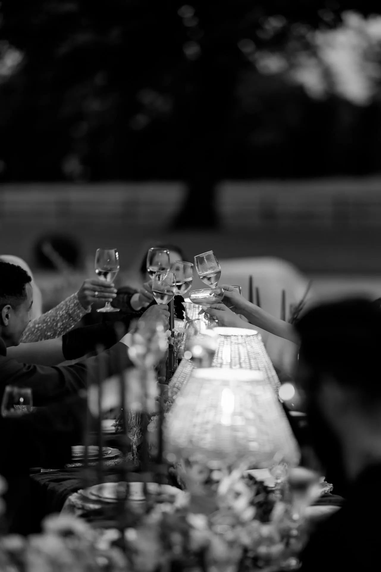 Schwarz-Weiß Hochzeitsgäste stoßen mit Weingläsern an bei eleganter Abendfeier am Chateau de Varennes